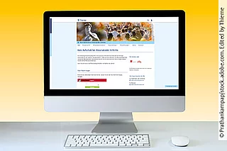 Monitor mit Screenshot der Startseite der Infothek. Davor liegen eine Tastatur und eine Mouse.