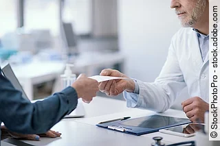 Doctor giving a certificate to his patient Doctor giving a certificate to his patient
