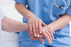 Close up of a nurse touching hand of a patient Close up of a nurse touching hand of a patient