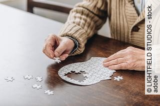 cropped view of senior man playing with puzzles 