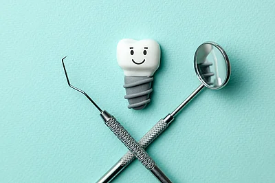 White teeth implants are smiling on green mint background and de White teeth implants are smiling on green mint background and de