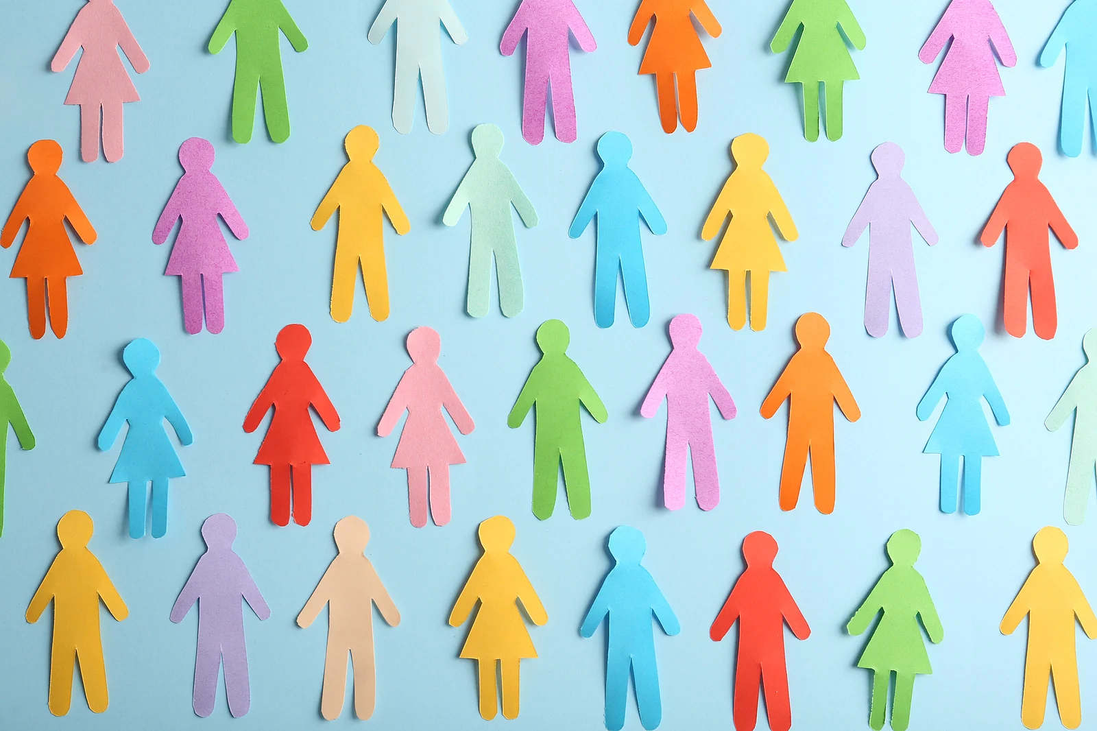 Many different paper human figures on light blue background, fla