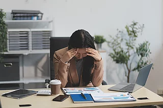 Portrait of tired young business Asian woman work with documents tax laptop computer in office. Sad, unhappy, Worried, Depression, or employee life stress concept