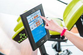 Person bedient Display eines SmartTouch Trainingsgerätes von HUR