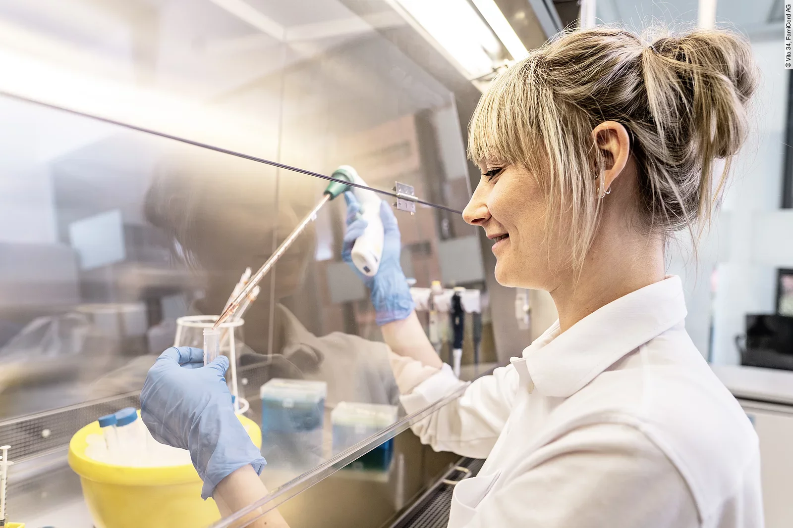 Wissenschaftlerin, die unter sterilen Bedingungen Proben untersucht.